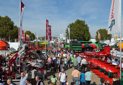 Zahlreiche Menschen laufen zwischen verschiedenen landwirtschaftlichen Fahrzeugen und Geräten über das LWH